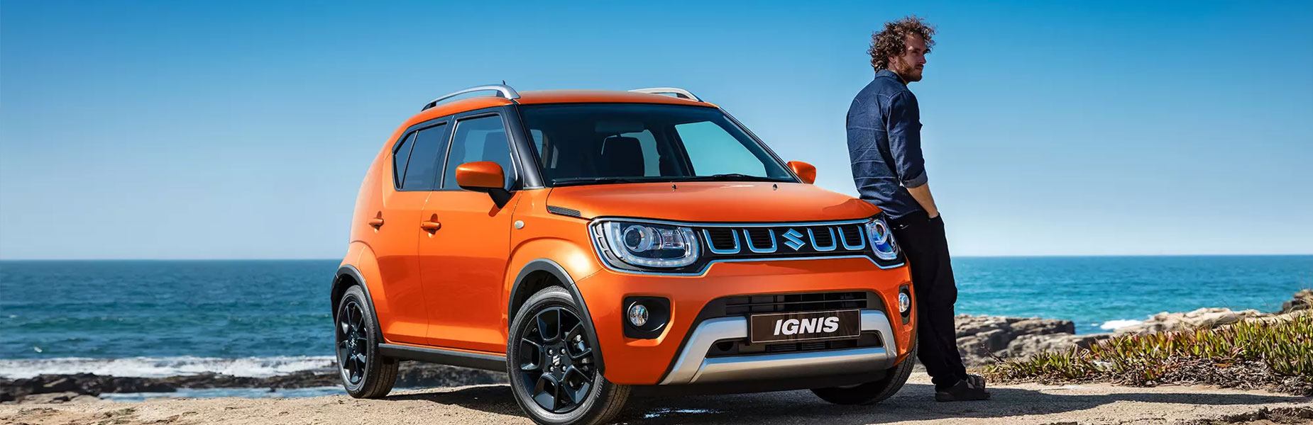 Red suzuki driving in a city at night