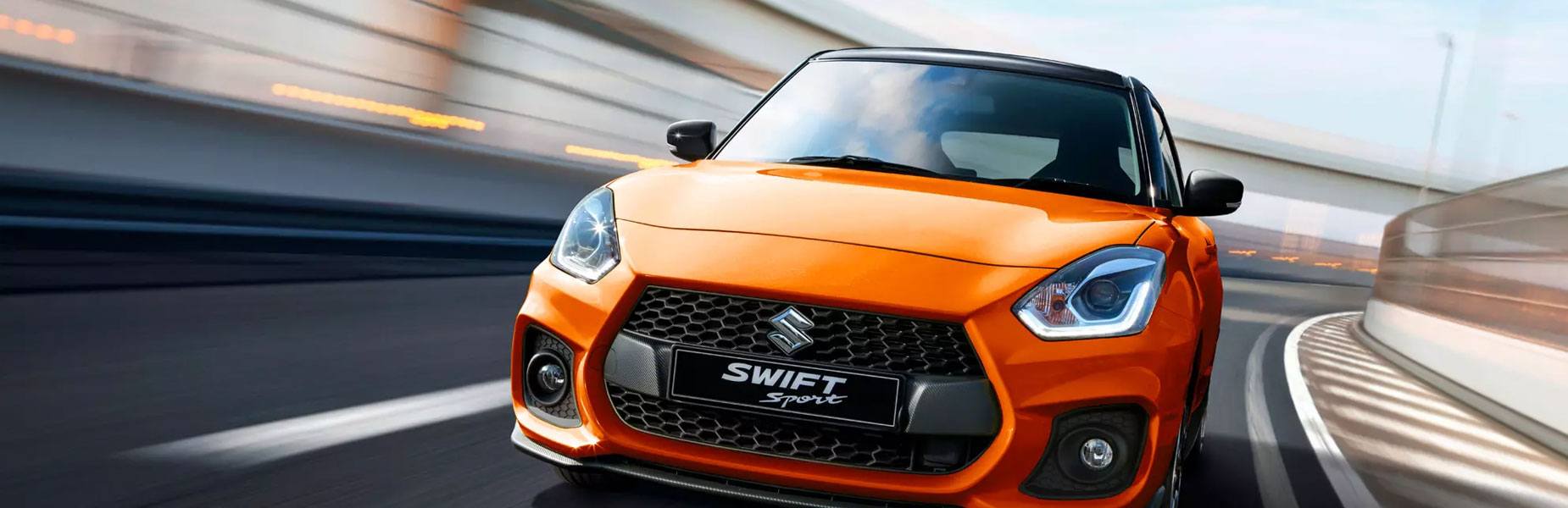Render of an Orange Suzuki Swift sport on a race track