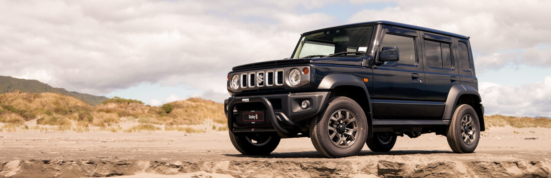 Red SUV driving off-road next to a cliff