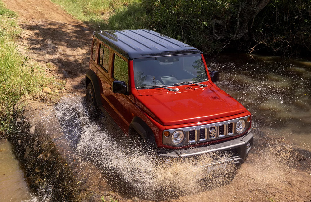 Red SUV driving through water & mud