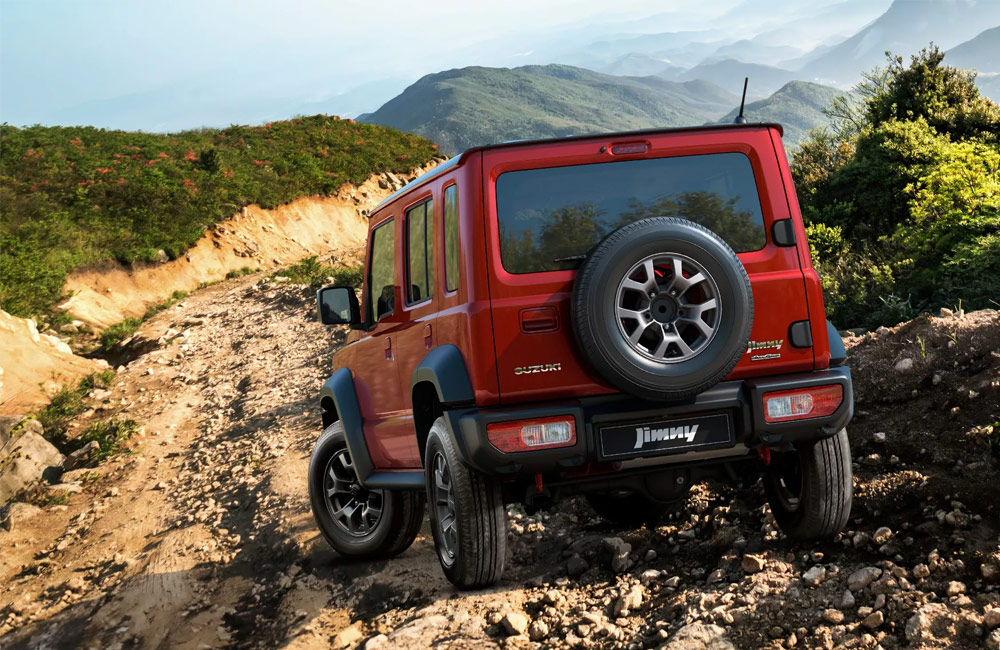 Rear of a Suzuki Jimny driving over rocks