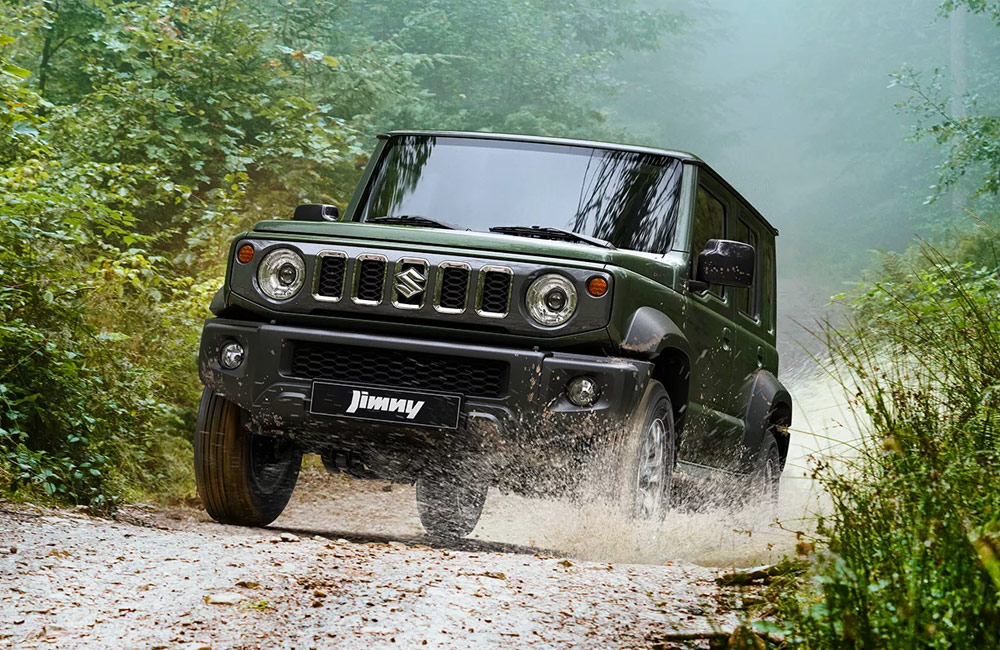 Green SUV driving off-road through water