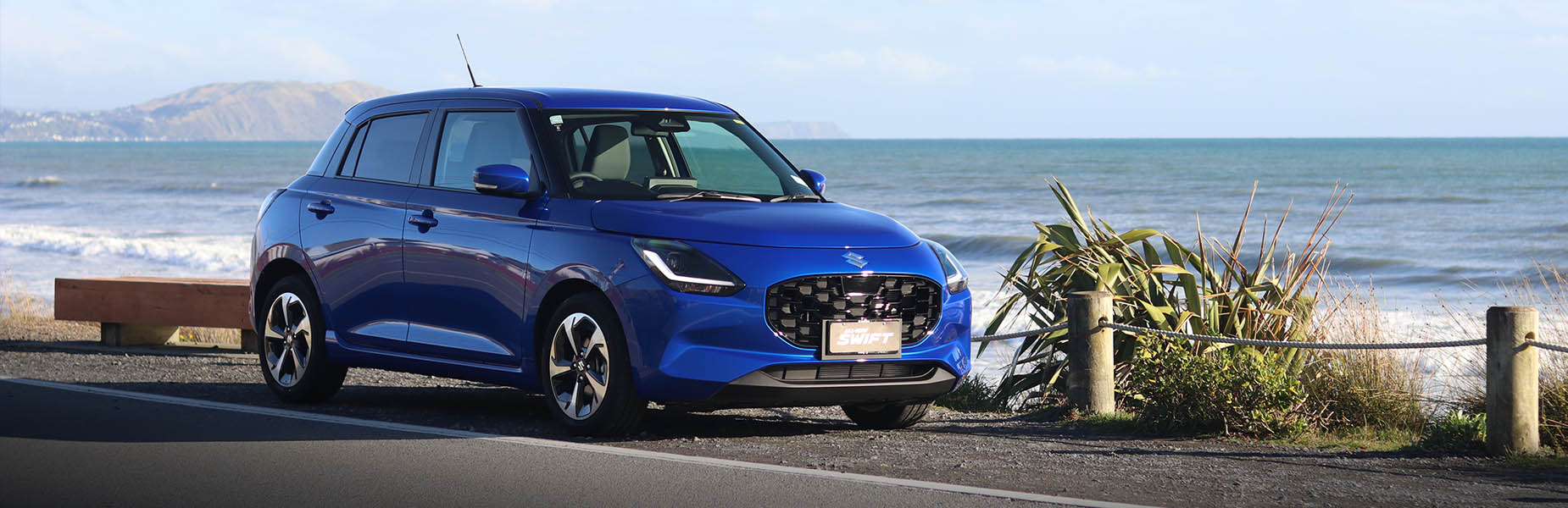 blue suzuki driving in a city