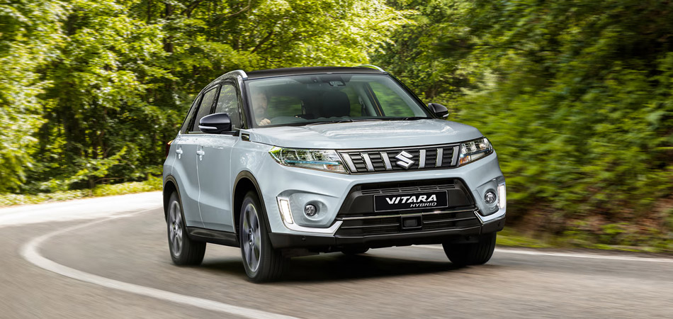 Silver Vitara Hybrid driving on a forest road