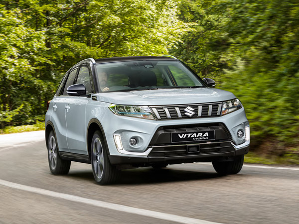Silver Vitara Hybrid driving on a forest road